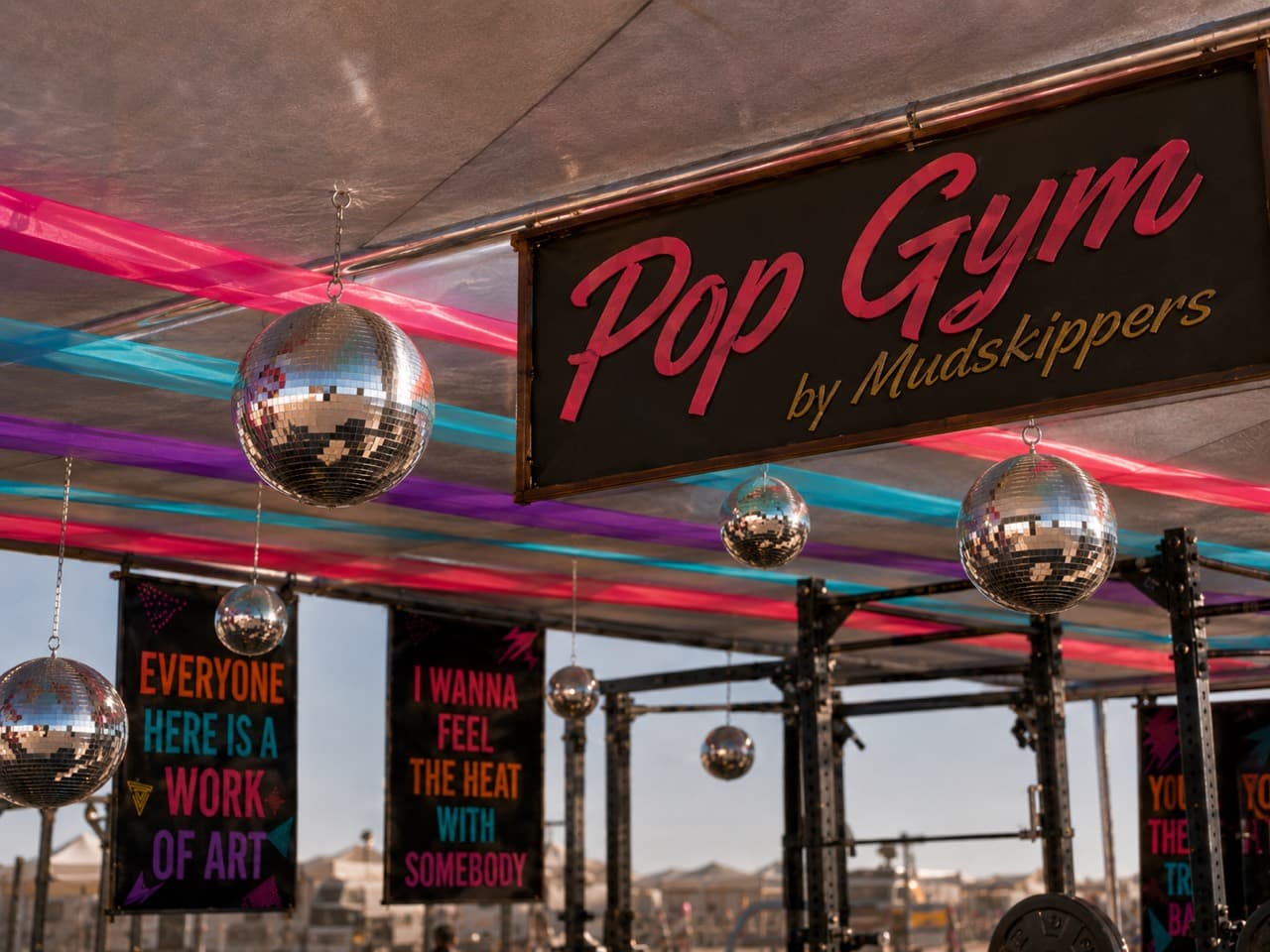 Pop Gym by Mudskippers sign surrounded by disco balls and bright 80s and 90s-inspired decor